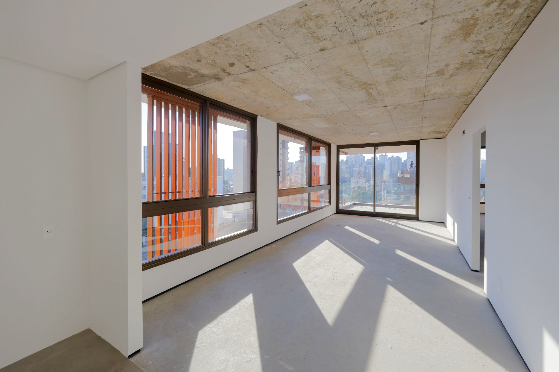 Interior de apartamento do IDEA Bagé com vidros de alto desempenho e vista para Porto Alegre